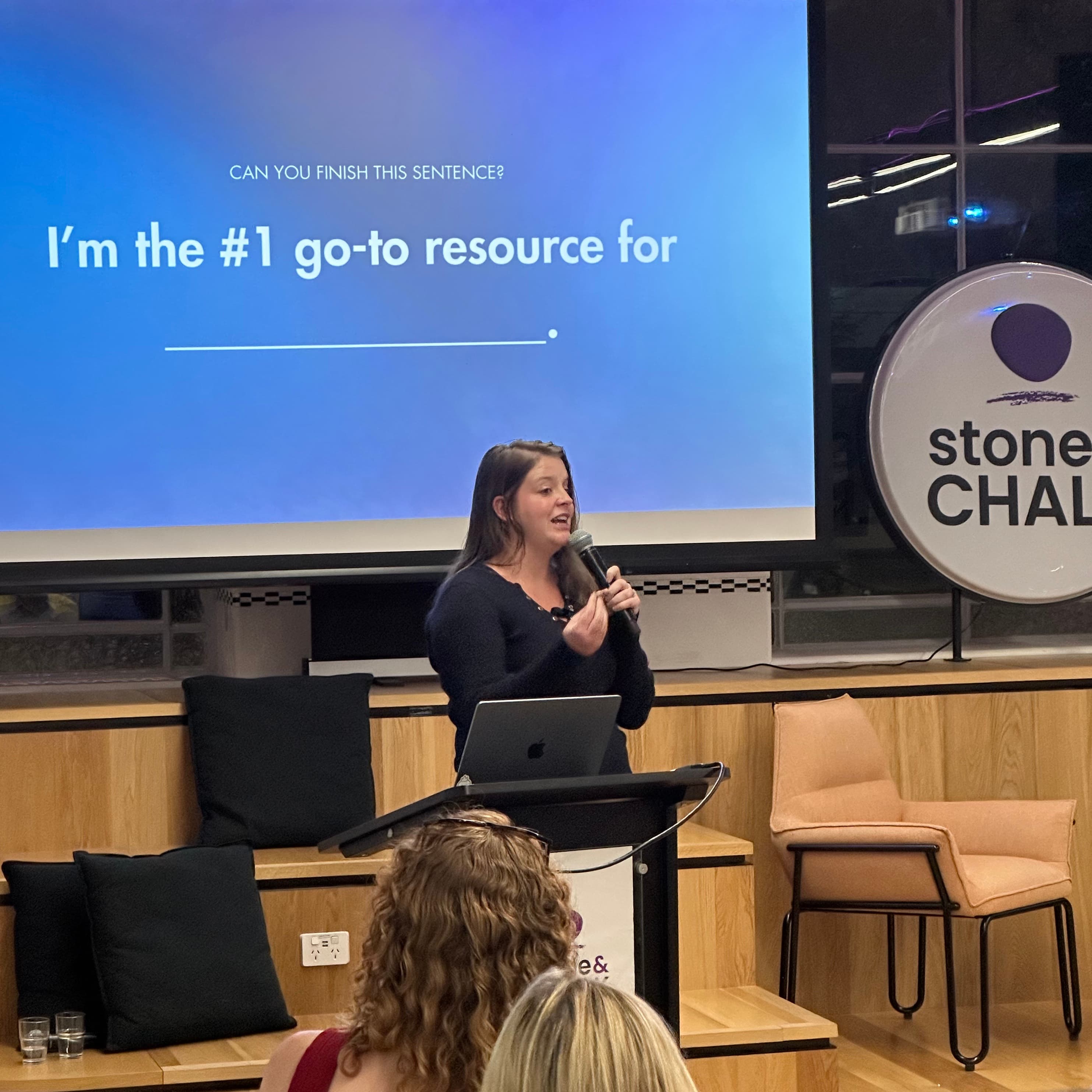 Lucy Bloomfield speaking on stage at an event